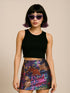 High-waisted fitted mini skirt featuring a vibrant tiger print in rainbow colors over a blue and purple camouflage background. The skirt includes a 1.5” elastic waistband and is made of eco polyester and spandex. Pencil fit hugs the body with a smooth silhouette. Available in performance or glitter finish, sizes S to XL.